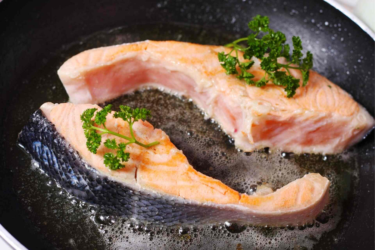 undercooked salmon in a frying pan