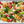 Baked fish fillets glazed with chili oil alongside baby red potatoes and broccolini in a white baking tray on a striped cloth
