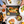 Overhead view of a dinner table with salmon topped with lemon slices, roasted potatoes, salad and a glass of white wine