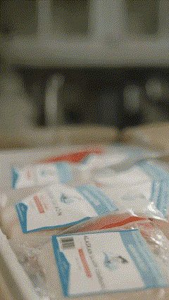 Vacuum-sealed fish portions packed side by side in an opened white insulated box